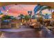 Spacious backyard featuring an outdoor kitchen, fire pit, and palm trees creates an outdoor living space at 5779 Baffy Cir, Las Vegas, NV 89142