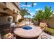 Backyard with a cozy fire pit, comfortable chairs, and lush landscaping at 5779 Baffy Cir, Las Vegas, NV 89142