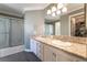 Bathroom featuring double sinks, granite countertops, and a shower with glass doors at 5779 Baffy Cir, Las Vegas, NV 89142