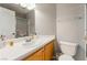 Well-lit bathroom with wooden cabinets, single sink, and toilet at 5779 Baffy Cir, Las Vegas, NV 89142