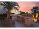 Beautiful outdoor kitchen features a stone surround, stainless grill, and picturesque backyard at 5779 Baffy Cir, Las Vegas, NV 89142