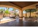 Covered patio featuring tiled floors, an outdoor table, and a charming backyard with lush trees at 5779 Baffy Cir, Las Vegas, NV 89142