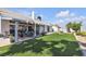 Beautiful backyard featuring a covered patio, manicured lawn and desert landscaping at 5990 Ablette Ave, Las Vegas, NV 89122