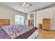 Primary bedroom boasts hard wood flooring, light walls, ceiling fan, and slider to backyard at 5990 Ablette Ave, Las Vegas, NV 89122