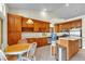 Well-lit kitchen with wooden cabinets, dining area, and stainless-steel appliances at 5990 Ablette Ave, Las Vegas, NV 89122