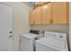 Functional laundry room with washer, dryer, and overhead cabinets at 5990 Ablette Ave, Las Vegas, NV 89122