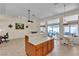 Open living room with neutral tile floors and access to the kitchen and patio at 5990 Ablette Ave, Las Vegas, NV 89122