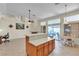 Open living room with neutral tile floors and access to the kitchen and patio at 5990 Ablette Ave, Las Vegas, NV 89122