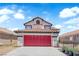 Charming two-story home features a red garage door, a tile roof, and an arched window at 6374 Horizon Ridge Ct, Las Vegas, NV 89156