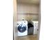 Bright laundry area with a white washer, dryer, and shelving for storage at 6374 Horizon Ridge Ct, Las Vegas, NV 89156