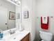 Clean and functional bathroom with a vanity, toilet, and mirror, adorned with framed art and colorful towels at 6630 Bubbling Brook Dr # C, Las Vegas, NV 89107