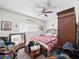 Bedroom featuring eclectic decor, a ceiling fan, and a large wooden armoire at 6630 Bubbling Brook Dr # C, Las Vegas, NV 89107