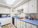Functional kitchen featuring clean white cabinetry, blue countertops, and essential appliances at 6630 Bubbling Brook Dr # C, Las Vegas, NV 89107