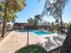 Community pool surrounded by mature trees and lounge chairs at 6630 Bubbling Brook Dr # C, Las Vegas, NV 89107