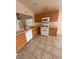Functional kitchen with tile floors, light wood cabinetry, and white appliances at 6642 Cinnabar Coast Ln, North Las Vegas, NV 89084