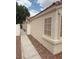A neutral colored exterior is accented by trimmed windows and concrete sidewalk at 6642 Cinnabar Coast Ln, North Las Vegas, NV 89084