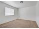 Bedroom with neutral carpeting, white walls, and a bright window at 6727 E Washington Ave, Las Vegas, NV 89110