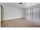 Spacious bedroom with neutral carpet, large window for natural light, and a closet with sliding doors at 6727 E Washington Ave, Las Vegas, NV 89110