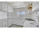 Bright kitchen with white cabinetry, tile countertops, and a window providing natural light at 6727 E Washington Ave, Las Vegas, NV 89110