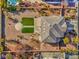 Aerial shot of desert home with spacious yard with landscaping, fire pit, and covered patio at 6971 Cedar Basin Ave, Las Vegas, NV 89142