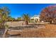 A large backyard is gravel-covered and features desert landscaping and several palm trees at 6971 Cedar Basin Ave, Las Vegas, NV 89142