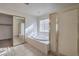 Bathroom featuring a soaking tub with a glass door and window at 6971 Cedar Basin Ave, Las Vegas, NV 89142