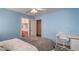 Comfortable bedroom featuring blue walls, ceiling fan and an adjacent bathroom at 6971 Cedar Basin Ave, Las Vegas, NV 89142