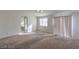 Spacious bedroom featuring neutral carpet, a window and a sliding door at 6971 Cedar Basin Ave, Las Vegas, NV 89142