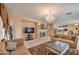 Cozy living area with a fireplace, mounted TV, chandelier, and an open layout that flows into the kitchen at 6971 Cedar Basin Ave, Las Vegas, NV 89142