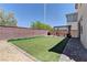 Spacious backyard with artificial turf, pergola-covered patio, and brick perimeter wall at 7104 Flathead River Ave, Las Vegas, NV 89179