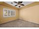 A spacious bedroom showcases neutral carpet, ceiling fan, and a window with shutter style blinds at 728 Hardy Way # E, Mesquite, NV 89027