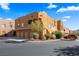 Exterior shot of the building showcasing the facade, landscaping, garages, and surrounding street at 728 Hardy Way # E, Mesquite, NV 89027
