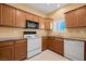 Charming kitchen featuring wood cabinetry, granite countertops, and white appliances, offering a blend of style and utility at 728 Hardy Way # E, Mesquite, NV 89027