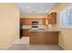 Cozy kitchen with warm wood cabinets, granite countertops, and modern appliances, complemented by natural light and ample workspace at 728 Hardy Way # E, Mesquite, NV 89027