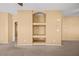 Spacious living room featuring neutral walls and carpet with custom built-in shelving for seamless style and functionality at 728 Hardy Way # E, Mesquite, NV 89027