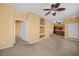 Spacious living room featuring neutral paint and carpet, ceiling fans, and a view into the kitchen at 728 Hardy Way # E, Mesquite, NV 89027