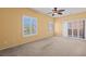 Spacious living room featuring neutral paint, ceiling fan, shutters, and a sliding door to the balcony at 728 Hardy Way # E, Mesquite, NV 89027