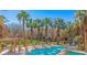 Inviting community pool with mature palm trees, tanning deck, and covered seating, a perfect vacation spot at 728 Hardy Way # E, Mesquite, NV 89027