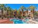 Relaxing community pool with mature palm trees and a nearby hot tub, a perfect vacation spot at 728 Hardy Way # E, Mesquite, NV 89027