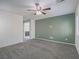 Spacious bedroom showcasing neutral carpet, ceiling fan, and an ensuite bathroom at 7753 Petite Pillar Ct, Las Vegas, NV 89149