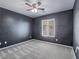 Bedroom features dark blue accent wall, neutral carpet, and ceiling fan at 7753 Petite Pillar Ct, Las Vegas, NV 89149