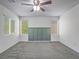 Bright bedroom features neutral carpet, three windows, and a ceiling fan at 7753 Petite Pillar Ct, Las Vegas, NV 89149
