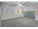Bright bedroom features neutral carpet, three windows, and a ceiling fan at 7753 Petite Pillar Ct, Las Vegas, NV 89149