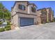 Charming townhome with a gray garage door, desert landscaping, and a well-kept exterior at 7753 Petite Pillar Ct, Las Vegas, NV 89149