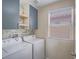 Bright and airy laundry room features newer washer and dryer, storage cabinets, and shelving at 7753 Petite Pillar Ct, Las Vegas, NV 89149