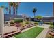 Backyard features a charming brick patio, palm trees, and artificial grass at 805 Palmero Way, Boulder City, NV 89005