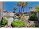 Inviting backyard featuring a patio, palm trees, storage shed, lush greenery and a dining set at 805 Palmero Way, Boulder City, NV 89005