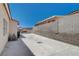 Long concrete driveway leading to a fenced area of the property with a wall along the side at 805 Palmero Way, Boulder City, NV 89005