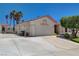 Beige house featuring a two-car garage, desert landscaping, and a concrete driveway at 805 Palmero Way, Boulder City, NV 89005