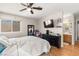 Comfortable bedroom featuring a ceiling fan, mounted tv, hardwood floors, and ensuite bathroom at 8505 Lansdale Rd, Las Vegas, NV 89123